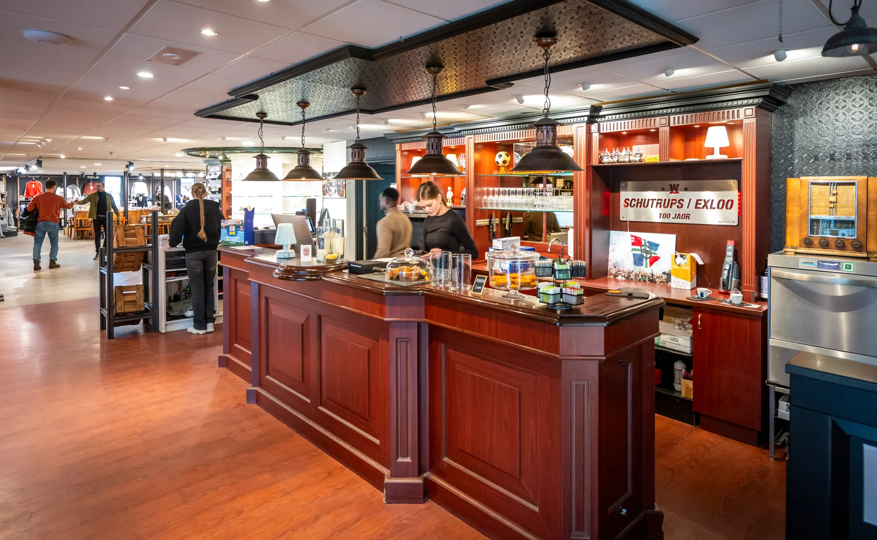 Collega's en klanten bij de koffiebar in de winkel in Exloo